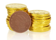 Delicious chocolate gold coins by Morkes Chocolates arranged in a stack. One of the coins is unwrapped to showcase the inside