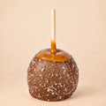 A milk chocolate caramel apple with sea salt from Morkes Chocolate set on a warm beige background