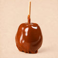 A plain caramel apple from Morkes Chocolates, placed on a warm beige background. 